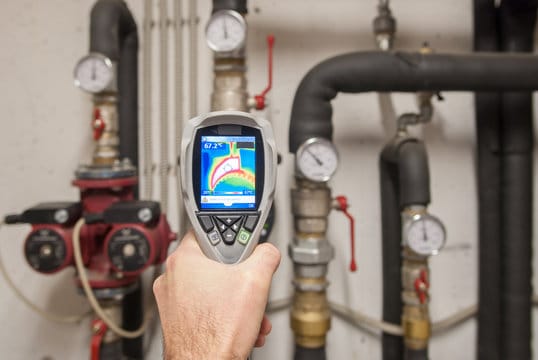 Plumber using a thermal imaging camera to inspect pipes in Ramona